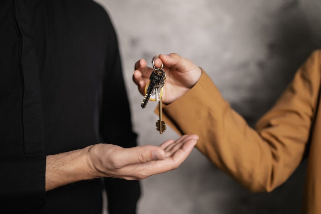 pexels-photo-7642000 Detailed close-up of one person handing over keys to another, symbolizing a real estate transaction.
