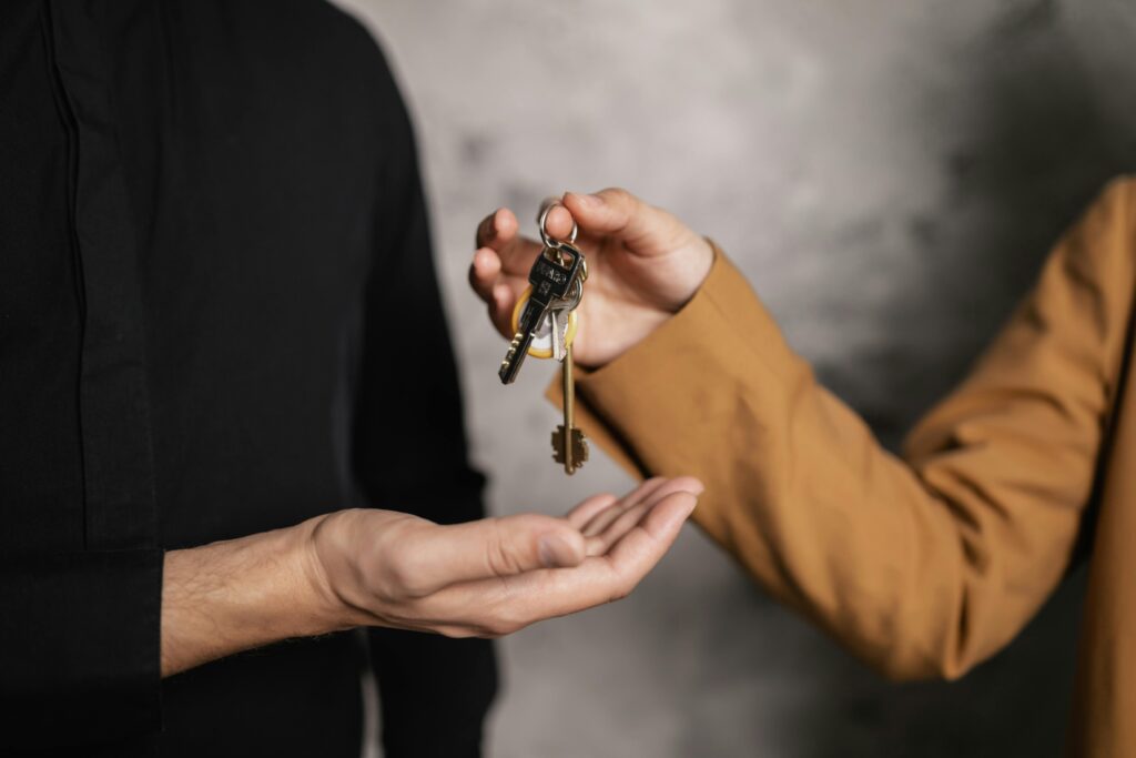 pexels-photo-7642000-7642000 Detailed close-up of one person handing over keys to another, symbolizing a real estate transaction.